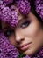 Make up close up in pink and purple shades and with flowers around face. Inspiration of spring. Beauty and cosmetics