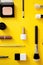 Make up flat lay. Cosmetics accessories on yellow background knolling concept.