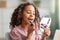 Daily make up. Happy teenage lady applying lipstick, holding mirror and looking at herself