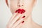 Make up and manicure set. macro cropped image of beautiful gradient of red black manicure and lipstick isolated on white