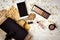 Make-up stuff, mobile phone and female bag on white table with leaves