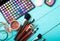 Make-up tools. Make up products. Lipstick, eye shadow, brushes. Cosmetics on blue wooden background. Selective focus