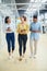 Make way for the go getters. a group of young businesspeople having a discussion while walking through a modern office.