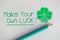 Make your own luck text on white paper near four leaf clover as lucky symbol