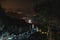 Makes marriage proposals. Two tourists on top of the mountain. Climbing, hiking trail. View of the night city. Romantic setting.