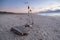 Makeshift wooden raft on a sandy beach at dusk. Perhaps built by a castaway