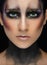 Makeup art and beautiful model theme: beautiful girl with a creative make-up black-and-purple and gold colors on a black backgroun