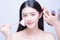 Makeup artist applies hair and skintone. Beautiful Asian woman face. Perfect makeup. Skincare foundation