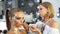 Makeup artist applying golden shiny powder on the model`s hair using special brush. Preparing for the fashion show