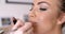 Makeup Artist Applying Lipstick to Pretty Woman