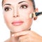 Makeup artist applying liquid tonal foundation on the face