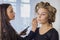 Makeup artist applying liquid tonal foundation on the face of the woman