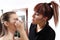 Makeup artist applying mascara on eyes of model