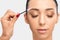 Makeup artist combs eyebrows with a brush after dyeing in a beauty salon.Professional makeup and cosmetology skin care