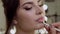 Makeup artist paints lip models in a makeup cosmetic salon. Beauty face.
