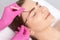 Makeup artist plucks eyebrows in a beauty salon. Professional makeup and cosmetology skin care