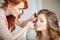 Makeup artist preparing bride before the wedding in a morning