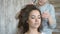 Makeup artist stylist works with model. hairdresser does the hair styling of the model. hair stylist creates a volume on