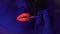 Makeup artist uses brush to apply fluorescent lipstick to model`s lips. Portrait of young woman painted with fluorescent