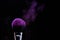 Makeup brush and purple blush splashes on a black background
