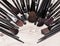 Makeup brushes arranged in semicircle on shabby wooden surface