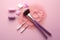 Makeup brushes with crushed eyeshadow palette on pink background - Ai Generated