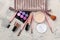 makeup kit. Women`s cosmetics in a cosmetic bag and makeup brushes on a light concrete background. women things. top view