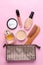 Makeup kit. Women`s cosmetics in a cosmetic bag and makeup brushes on a pink bright background. women things. top view