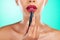 Makeup, lipstick apply and a model black woman in studio on a green background for a cosmetic product. Cosmetics, mouth