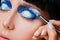 Makeup. Make-up. Painting blue eyeshadows. Eye