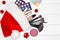 Makeup products in Santa hat on white wood boards - top view. Make-up cosmetics as Christmas gift concept. Copy space