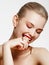Makeup products. Young beautiful girl with gold earrings and ring smiling on white background. Red nails with manicure