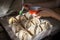 Making apples baked in dough. Woman`s hands spreading egg yolk onto raw pastry items with silicone culinary brush