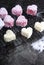 Making Australian style pink heart shape small lamington cakes - vertical close up.