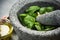 Making basil pesto in granite mortar