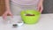 Making bread from green buckwheat. A woman adds flax, sunflower and pumpkin seeds to the green buckwheat dough