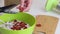 Making bread from green buckwheat. A woman cuts dried apricots into green buckwheat dough with scissors. Close-up shot