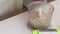 Making bread from green buckwheat. A woman puts buckwheat in a blender bowl for grinding. Close-up shot