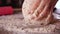 Making bread or pizza - woman hands mixing ingredients and kneading the dough