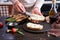 Making breakfast toasts - woman smearing cream cheese on a grilled bread over kitchen table with Asparagus wrapped with