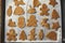 Making christmas gingerbread cookies, flat lay. Raw dough in shape of gingerbread man,christmas tree, star, deer on paper on tray