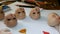 Making dolls. Master painter carefully paints lips of blank for doll with thin brush. Concept of combining work and