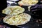 Making of egg roll on a hot frying pan with oil and paratha and salad