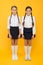 Making everything right. Excellent pupils. Girls perfect uniform outfit on yellow background. According to school rules