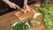 Making green juice at home: Male hands cut banana with a knife on a board table in the kitchen. Unrecognizable fitness