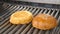 Making and grilling hamburger buns with sesame on coal grill. Preparing roasted food on barbecue BBQ grill in outdoor