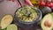 Making guacamole sauce - woman mixing chopped ingredients in marble bowl mortar