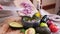 Making guacamole sauce - woman pouring chopped red mars onion into bowl with mashed avocado