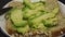 Making a healthy avocado sandwich. Close-up of a knife spreads a layer of ripe soft avocado on a piece of cereal bread.