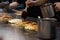Making a Hiroshima style layered pancake. Hand spreading a sweet Okonomiyaki sauce on a hot pan